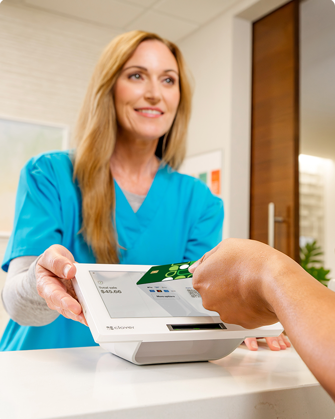 Medical office employee accepting a Clover card payment